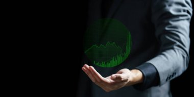 Elinde yeşil çizelge tutan bir işadamı.