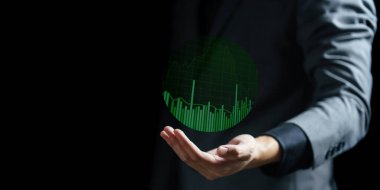 ekranda bulanık yeşile karşı grafik simgesi olan elin dijital bileşimi