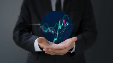 İşadamı eli dijital ekranda bir hisse grafiği çiziyor.