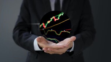 Grafik, borsa ve borsa ile dijital tablet tutan işadamı