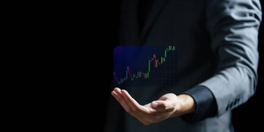 Siyah arka planda sanal bir grafik tutan bir iş adamı. borsa konsepti.