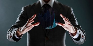 İş adamı elinde iş grafiği grafiği ve grafik grafiği olan sanal bir ekran tutuyor. iş ve teknoloji kavramı.