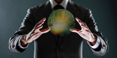 Takım elbiseli iş adamı, holografik 3 boyutlu görüntüleme cihazıyla dünyayı tutuyor.