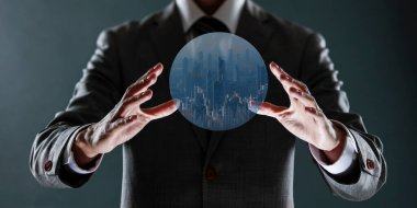 Bir iş adamı elleriyle bir küre tutuyor.