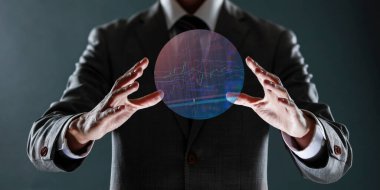 İşadamı parmaklarıyla holografik küreyi tutuyor.