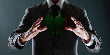 Finansal konsept, elinde eliyle bir tablo tutan işadamı, borsa ve borsa grafiği ekranda..