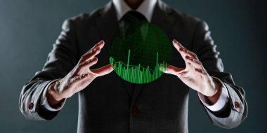 Takım elbiseli iş adamı ve elinde bir grafikle yeşil gömlekli. Elinde grafik var..