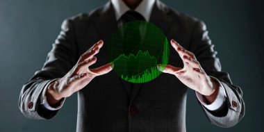 İşadamı elinde bir borsa haritasının sanal bir yansımasını tutuyor.