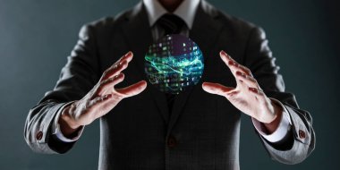 Dünya gezegeniyle çevrili bir küreyi elinde tutan iş adamı