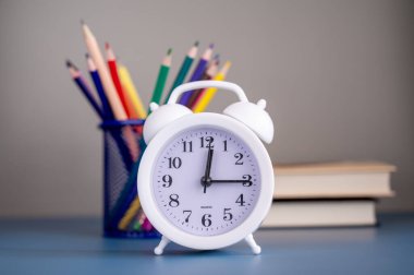 Okula dönüş konsepti. Kitaplar, okul kağıtları ve çalar saat.