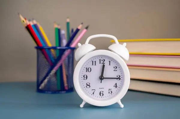 Okula dönüş konsepti. Kitaplar, okul kağıtları ve çalar saat.