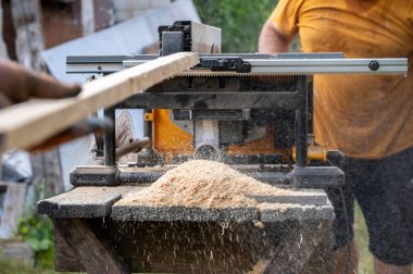 Tahtayı dairesel testere ile kesen bir adam.