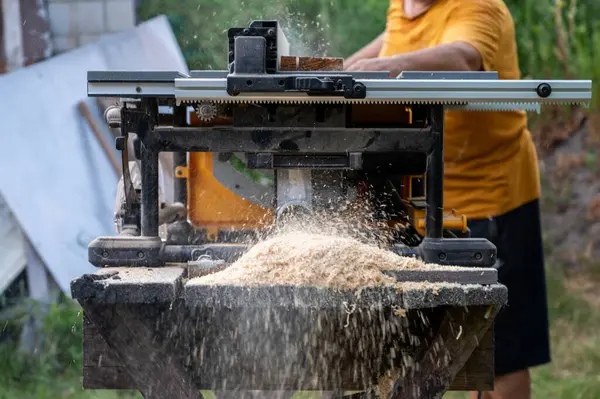 Tahtayı dairesel testere ile kesen bir adam.