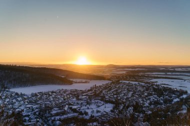 Karla kaplı bir kasabada gün batımı