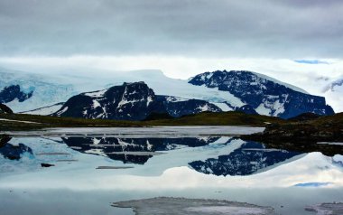 Karlı ve dağlı güzel bir manzara.