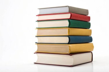 Düzenli sekiz ciltli kitap yığını, temiz beyaz bir arkaplan karşısında çeşitli renk ve boyları göstermektedir.