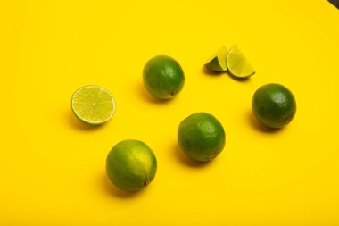 Sarı arka planda limon ve limon dilimleri, perspektif görünümü