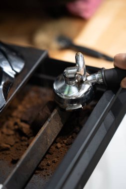 Portafilter kahve kabına atıldı, yakın plan, barista çalışma alanında izole edildi..