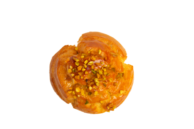 Karamelli jöle ve doğranmış şam fıstığı ile kaplanmış parlak altın hamur işi. Üst görünüm, şeffaf arkaplan, PNG