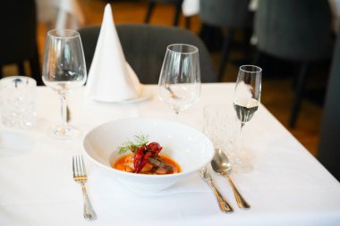 Zarif restoran masasının önünde gurme deniz ürünleri çorbası.