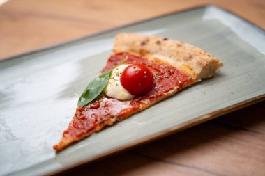 Tek dilim Margherita pizza.