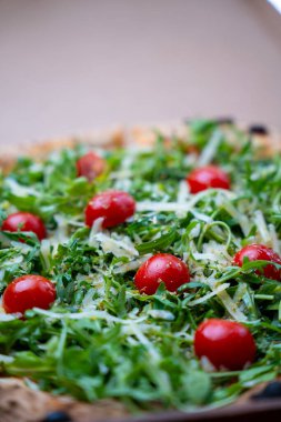Arugula ve vişneli domates pizzası yakın plan.