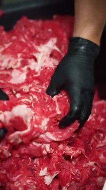 Yakın plan eldivenle kesilmiş çiğ sığır eti.