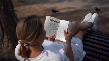 Parkta kitap okuyan kadın.