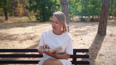 Parkta kitap okuyan kadın.