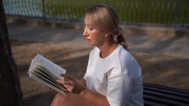 Parkta kitap okuyan kadın.