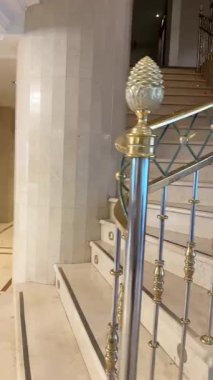 Lüks mermer bir merdivende altın parmaklıklar ve ışıklarla yürüyorum.. 