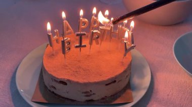 Kutlama sırasında pastadaki mumları çakmakla yakıyorum.. 