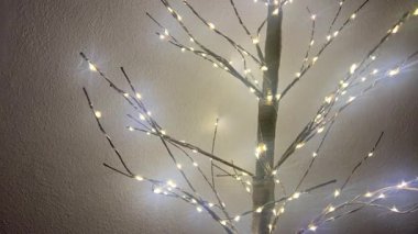 Dallarında ışıklar olan parıldayan dekoratif ağaç, kopyalama alanı, yeni yıl konsepti. 