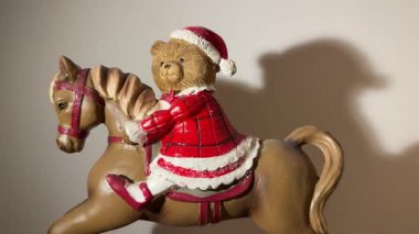 Christmas toy bear on rocking horse with gifts, festive holiday decoration. 