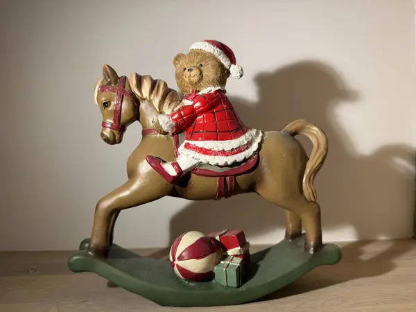 Christmas toy bear on rocking horse with gifts, festive holiday decoration. 