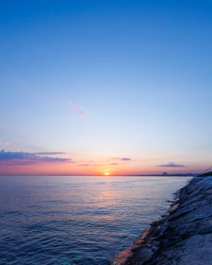Deniz kıyısında gün batımı, denizin üzerinde gün batımı. Denizin güzel doğal manzarası.