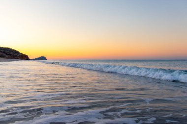 beautiful seascape with a rocky shore in a sunrise sky