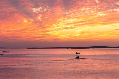 Glyaz Gölü üzerinde turuncu gün batımı ve balıkçı tekneleri
