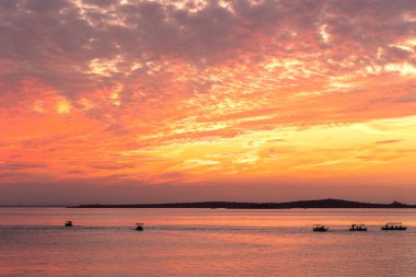 Glyaz Gölü üzerinde turuncu gün batımı ve balıkçı tekneleri