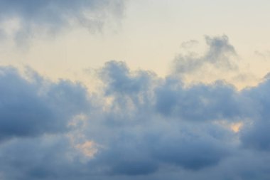 Fırtına bulutları ve bulutların arkasındaki güneş ile mavi gökyüzü