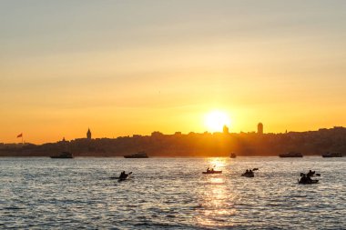  İstanbul 'da günbatımında İstanbul' da günlük faaliyet olarak insanların silueti kürek çekiyor.
