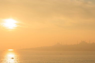 Arka planda cami, İstanbul, Türkiye, Smoky ve Foggy Air ile marmarmara denizi üzerinde güzel bir gün batımı