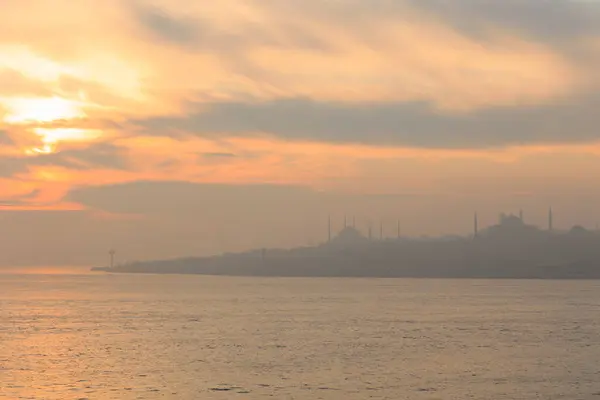 Arka planda cami, İstanbul, Türkiye, Smoky ve Foggy Air ile marmarmara denizi üzerinde güzel bir gün batımı