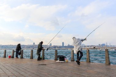 İstanbul 'da boğazında olta tutan bir balıkçı.