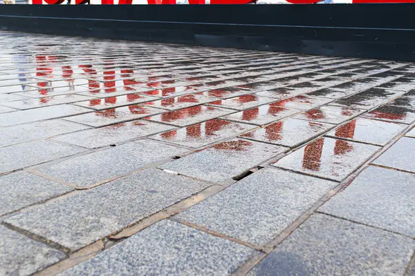 Yağmurlu bir günde kaldırımda İstanbul tahtası harflerinin yansıması, fotoğrafın yakın çekimi.