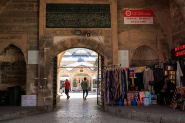 SOKULLU MEHMET Paşa Camii 'ne giden insanlar ve bir mağaza görevlisi 21 Nisan 2025' te Luleburgaz, Kirklareli 'deki mağazanın önünde oturuyorlar.