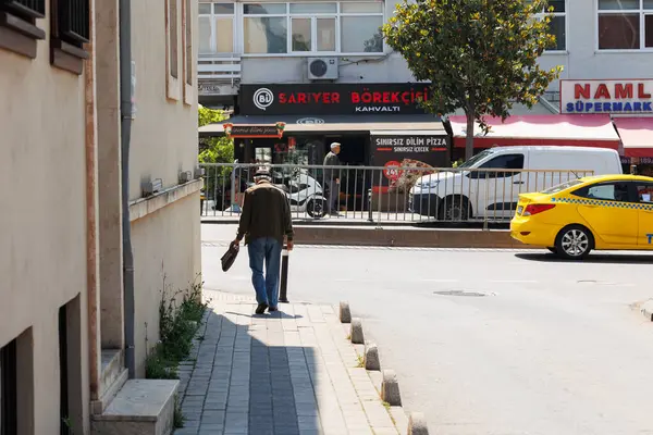 Yaşlı bir adam İstanbul, uskudar ve hindinin yol ve sokak manzarasına doğru yürüyor.