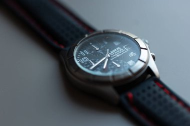 Siyah kadranlı ve gri arka planda kırmızı kayışlı bir kol saati, bir otel sabahında uyanmak için