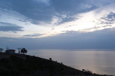Bir evin silueti ve Karadeniz üzerinde güzel bir gün doğumu.