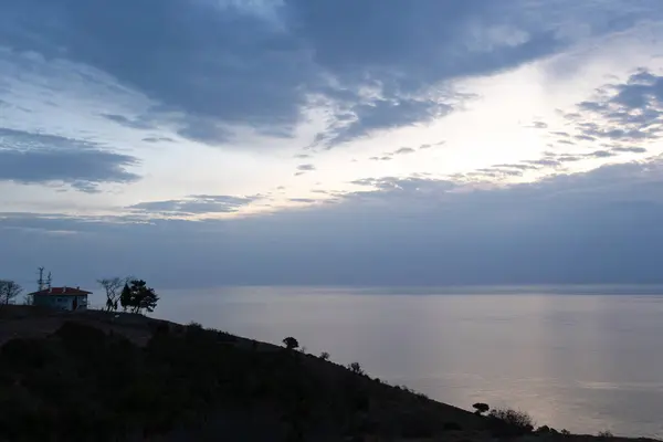 Bir evin silueti ve Karadeniz üzerinde güzel bir gün doğumu.